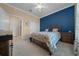 Cozy bedroom with a blue accent wall, carpeted floors, and a well-lit, comfortable atmosphere at 6376 Sw 97Th Terrace Rd, Ocala, FL 34481