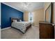 Comfortable bedroom featuring a blue accent wall, neutral tones, and ample natural light at 6376 Sw 97Th Terrace Rd, Ocala, FL 34481