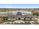 Exterior aerial view of the community clubhouse overlooking a lake, with palm trees and golf carts at 6376 Sw 97Th Terrace Rd, Ocala, FL 34481