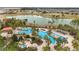 Beautiful aerial view of the community pool, featuring palm trees and a scenic lake backdrop at 6376 Sw 97Th Terrace Rd, Ocala, FL 34481