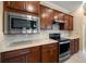 A stylish kitchen with dark wood cabinets, stone backsplash, and stainless appliances at 6376 Sw 97Th Terrace Rd, Ocala, FL 34481