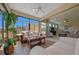 This sunroom offers ample light and leads into the home's tastefully decorated living room at 6376 Sw 97Th Terrace Rd, Ocala, FL 34481