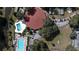 Bird's-eye view of the property with multiple pools, a central building with a red roof, and parking facilities at 660 Silver Pass, Ocala, FL 34472