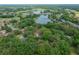 Aerial view showcases the home's proximity to a lake in a tree-filled neighborhood at 660 Silver Pass, Ocala, FL 34472