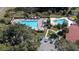 Aerial view featuring multiple pools, a hot tub, and ample lounge seating under colorful umbrellas at 660 Silver Pass, Ocala, FL 34472