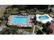 High-angle shot displays two pools, one with a hot tub, and numerous lounge chairs with umbrellas at 660 Silver Pass, Ocala, FL 34472