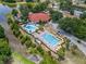 Aerial view of the property featuring a pool, tennis court, parking, and mature trees at 660 Silver Pass, Ocala, FL 34472