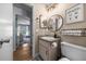 Cozy bathroom featuring a modern sink, decorative mirror, neutral-toned walls and an open door at 660 Silver Pass, Ocala, FL 34472