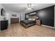 Comfortable bedroom features a wood bedframe, stylish dark accent wall and ceiling fan at 660 Silver Pass, Ocala, FL 34472
