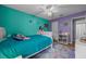 Bright bedroom featuring teal and purple walls, a ceiling fan, a colorful rug, and a cozy bed at 660 Silver Pass, Ocala, FL 34472