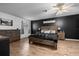 Comfortable bedroom features a wood bedframe, stylish dark accent wall and ceiling fan at 660 Silver Pass, Ocala, FL 34472