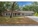 Charming single-story home with a well-manicured lawn, covered porch, and attached carport at 660 Silver Pass, Ocala, FL 34472