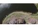 Aerial view featuring a scenic lakeside with lush greenery, a dock, and boats at 660 Silver Pass, Ocala, FL 34472