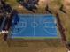 Aerial shot of the blue basketball court with pristine lines, fencing and landscaping at 7455 Sw 97Th Terrace Rd, Ocala, FL 34481