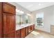Bathroom features dual sinks, cherry wood cabinets, granite counters and natural light at 7455 Sw 97Th Terrace Rd, Ocala, FL 34481