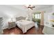Comfortable bedroom boasts hardwood floors, a ceiling fan, and access to a sunroom at 7455 Sw 97Th Terrace Rd, Ocala, FL 34481