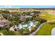 Aerial image of a lagoon-style pool area, complete with palm trees, sun loungers, and tropical landscaping at 7455 Sw 97Th Terrace Rd, Ocala, FL 34481