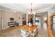 Open dining room with table, chairs, decorative chandelier, and an open view into the living room at 7455 Sw 97Th Terrace Rd, Ocala, FL 34481