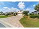 Paver driveway leads to a well-maintained home with lush landscaping at 7455 Sw 97Th Terrace Rd, Ocala, FL 34481