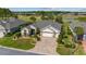 Aerial view of a beautifully landscaped home featuring a brick driveway, manicured lawn, and mature trees in a peaceful setting at 7455 Sw 97Th Terrace Rd, Ocala, FL 34481