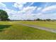 Picturesque view of the lush green golf course from the property, framed by mature trees and clear blue skies at 7455 Sw 97Th Terrace Rd, Ocala, FL 34481
