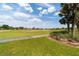 Scenic view of the golf course from the property's edge; sunny skies and lush green fairways create a picturesque landscape at 7455 Sw 97Th Terrace Rd, Ocala, FL 34481