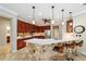 Kitchen featuring stone accent, bar seating, pendant lighting, stainless appliances, and wood cabinetry at 7455 Sw 97Th Terrace Rd, Ocala, FL 34481