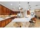 Kitchen featuring stone accent, bar seating, pendant lighting, stainless appliances, and wood cabinetry at 7455 Sw 97Th Terrace Rd, Ocala, FL 34481