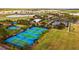 Aerial view of community tennis courts with blue surfaces surrounded by lush greenery and manicured landscaping at 7455 Sw 97Th Terrace Rd, Ocala, FL 34481