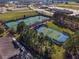 Aerial view showcasing several well-maintained community tennis courts with mature landscaping at 7455 Sw 97Th Terrace Rd, Ocala, FL 34481