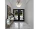 Elegant foyer with marble floors, decorative wrought iron doors, and a stylish chandelier at 7585 Nw 33Rd Pl, Ocala, FL 34482