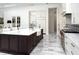 Bright kitchen with white marble floors, large island, stainless appliances, and custom cabinets at 7585 Nw 33Rd Pl, Ocala, FL 34482