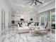 Bright, open-concept living room with a white sofa, marble floors, and modern decor at 7585 Nw 33Rd Pl, Ocala, FL 34482