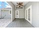 Relaxing covered back porch with wood decking and gray walls, a ceiling fan and lighting at 8 Banyan Dr, Ocala, FL 34472