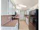 Kitchen with white cabinets, laminate countertops, and black appliances at 8 Banyan Dr, Ocala, FL 34472