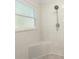 Shower features decorative tile, corner seat, and handheld shower fixture at 8 Banyan Dr, Ocala, FL 34472