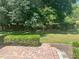 Expansive backyard with lush green grass, mature trees, brick paver patio and manicured hedges at 9019 Se 120Th Loop, Summerfield, FL 34491
