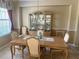 Elegant dining room with light wood table, upholstered chairs, and decorative china cabinet at 9019 Se 120Th Loop, Summerfield, FL 34491