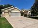 Stunning single-story home with a spacious driveway featuring decorative star accents and a well-maintained lawn at 9019 Se 120Th Loop, Summerfield, FL 34491