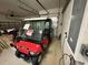Garage featuring a red 'Club Car' golf cart, offering convenience and leisure at 9019 Se 120Th Loop, Summerfield, FL 34491