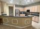 Bright kitchen showcasing updated stainless appliances and a breakfast bar for casual dining at 9019 Se 120Th Loop, Summerfield, FL 34491
