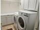 Well-equipped laundry room with white cabinets, shelving and modern washer and dryer units at 9019 Se 120Th Loop, Summerfield, FL 34491