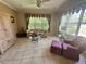 Inviting living room with neutral tones, floral sofa, ceiling fan and tiled flooring at 9019 Se 120Th Loop, Summerfield, FL 34491