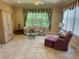 Cozy living room features a floral sofa, glass coffee table, and ample natural light at 9019 Se 120Th Loop, Summerfield, FL 34491