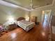 Spacious main bedroom featuring hardwood floors, a ceiling fan, and a private ensuite at 9019 Se 120Th Loop, Summerfield, FL 34491