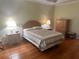 Comfortable main bedroom with wood floors offers a peaceful retreat with natural lighting at 9019 Se 120Th Loop, Summerfield, FL 34491