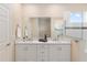 Bathroom with double sinks, white cabinets, and a walk-in shower with glass door at 9923 Sw 98Th Ln, Ocala, FL 34481