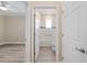Hallway view to a bathroom with tiled shower and tub with a grab bar at 9923 Sw 98Th Ln, Ocala, FL 34481