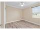Bright bedroom with laminate floors, ceiling fan, neutral walls, and a large window at 9923 Sw 98Th Ln, Ocala, FL 34481
