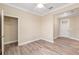 Neutral bedroom featuring wood-look floors, base trim, a large closet, and a view of the front entrance at 9923 Sw 98Th Ln, Ocala, FL 34481